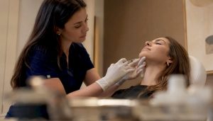 Nurse injecting chin filler in medical clinic